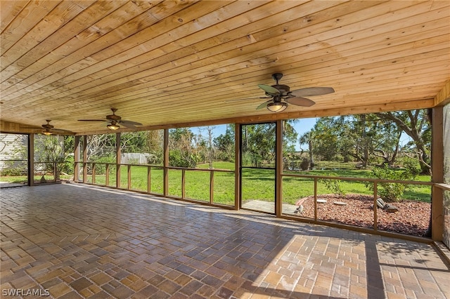 unfurnished sunroom featuring ceiling fan and wood ceiling