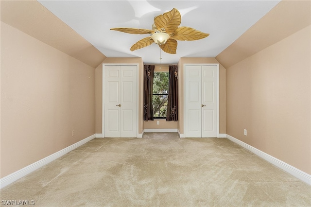 unfurnished bedroom featuring light carpet, ceiling fan, and lofted ceiling