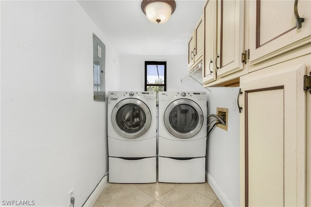 laundry room featuring light tile floors, washing machine and dryer, and cabinets