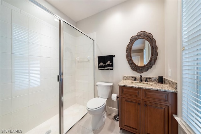 bathroom featuring tile patterned flooring, walk in shower, toilet, and vanity