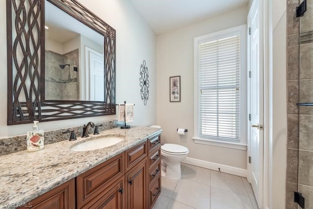 bathroom with tile patterned flooring, toilet, a tile shower, and vanity