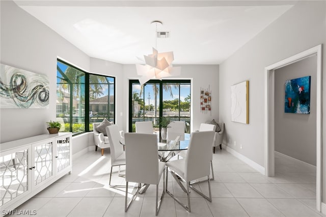 tiled dining space featuring an inviting chandelier