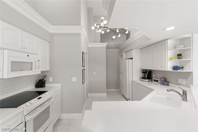 kitchen featuring white appliances, light tile flooring, white cabinets, sink, and a chandelier