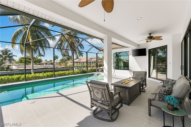 view of swimming pool featuring ceiling fan, glass enclosure, and a patio