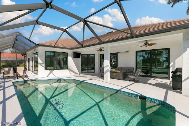 view of swimming pool featuring ceiling fan, glass enclosure, and a patio