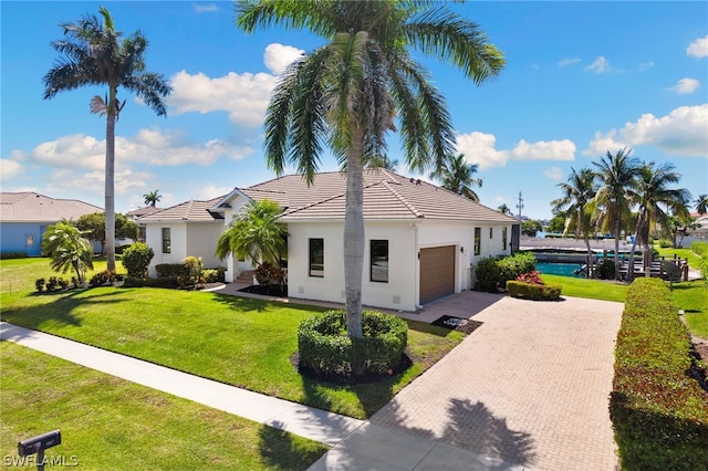 view of front of house featuring a garage, a pool, and a front yard