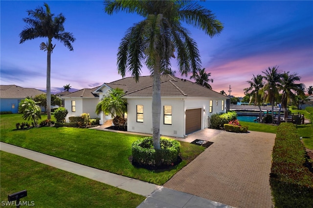 view of front facade with a garage and a lawn