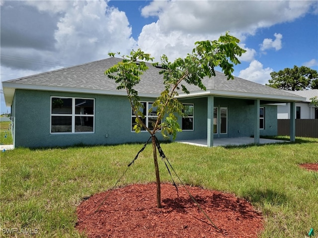 back of house featuring a lawn and a patio