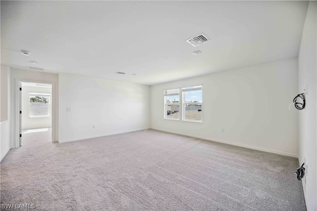 unfurnished room featuring light carpet