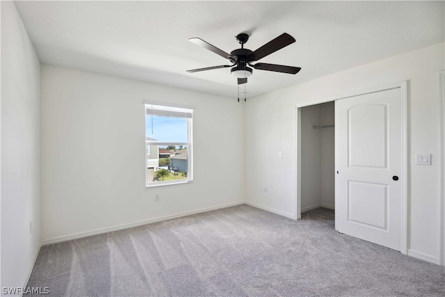 unfurnished bedroom featuring ceiling fan, light colored carpet, and a closet