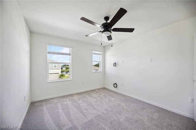 spare room featuring ceiling fan and light carpet