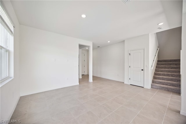 empty room featuring light tile patterned floors and plenty of natural light