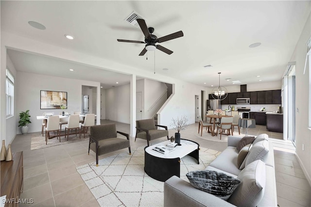 living room featuring ceiling fan with notable chandelier and light tile patterned flooring