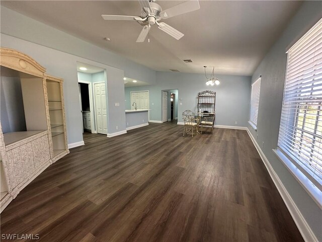 unfurnished living room featuring sink, dark hardwood / wood-style floors, and ceiling fan with notable chandelier