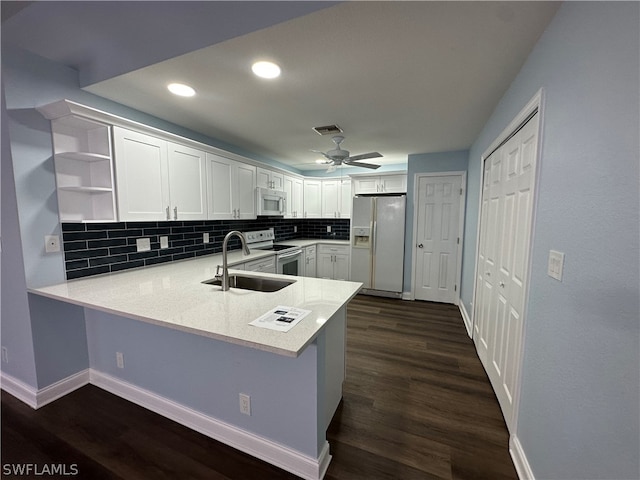 kitchen with dark hardwood / wood-style floors, ceiling fan, kitchen peninsula, white appliances, and sink