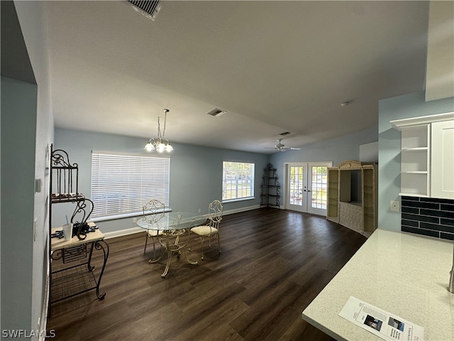 dining area featuring french doors, dark wood-type flooring, and ceiling fan with notable chandelier