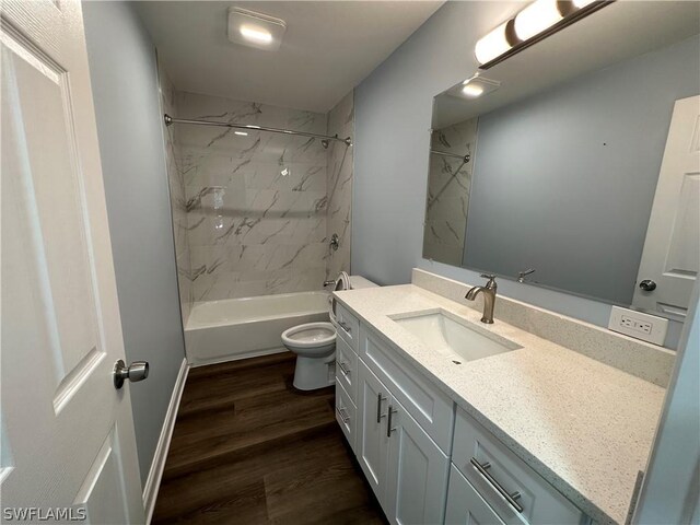 full bathroom with toilet, vanity, tiled shower / bath, and hardwood / wood-style floors