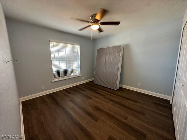 empty room featuring dark hardwood / wood-style floors and ceiling fan