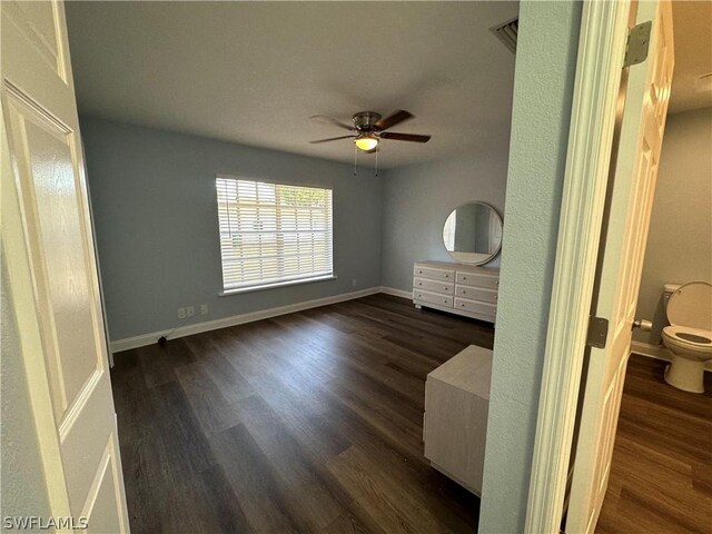 interior space featuring ensuite bath, ceiling fan, and dark hardwood / wood-style floors