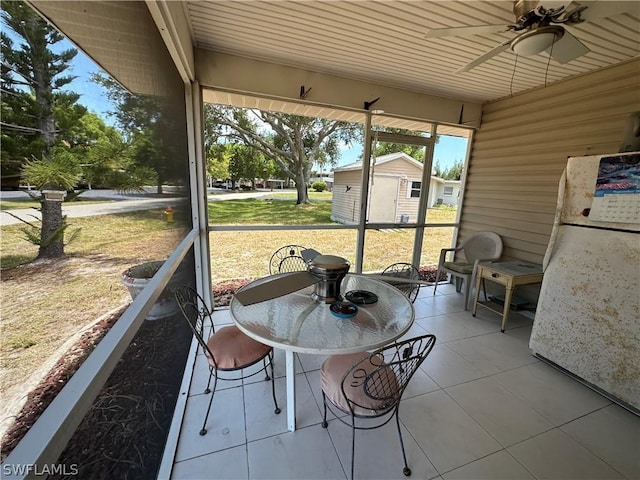 unfurnished sunroom with ceiling fan