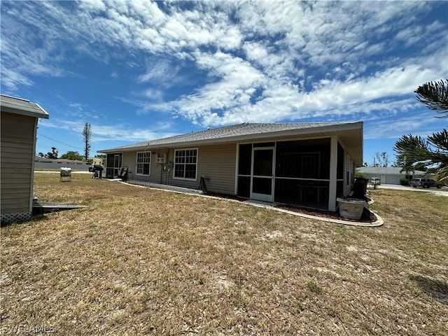 rear view of house with a sunroom and a lawn