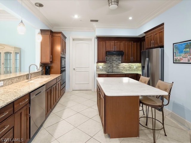 kitchen with decorative light fixtures, black appliances, ceiling fan, sink, and a breakfast bar area