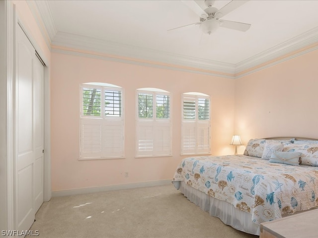 carpeted bedroom featuring a closet, ceiling fan, and ornamental molding