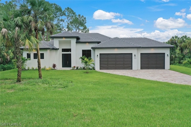 view of front of property with a front yard and a garage