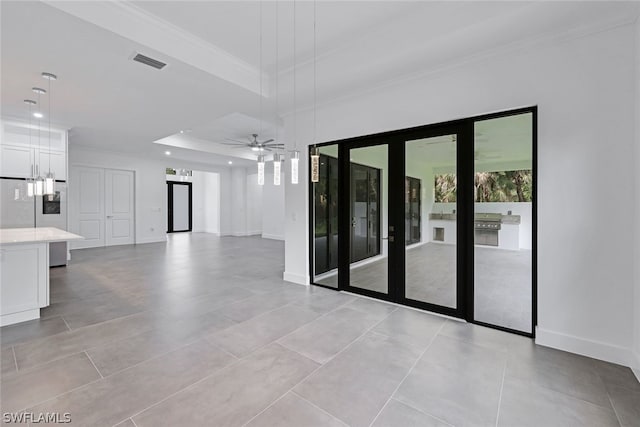 spare room featuring light tile flooring, a tray ceiling, and ceiling fan