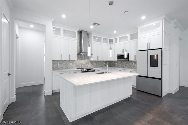 kitchen featuring wall chimney range hood, white cabinetry, and appliances with stainless steel finishes