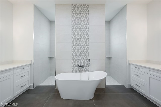 bathroom featuring tile walls, vanity, a bath, and tile flooring