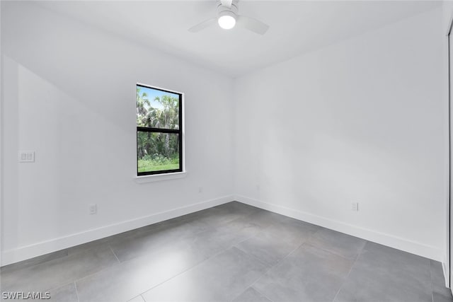 spare room featuring light tile floors and ceiling fan