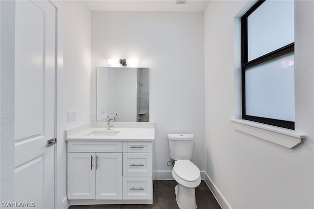 bathroom with vanity, tile floors, and toilet