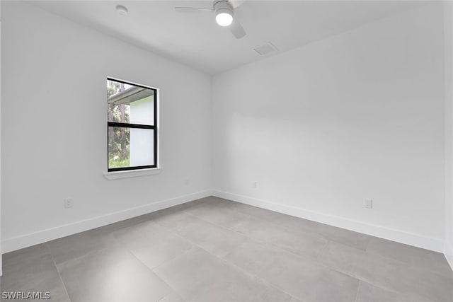 spare room featuring light tile floors and ceiling fan