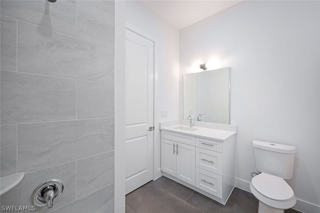 bathroom with toilet, tile floors, and large vanity