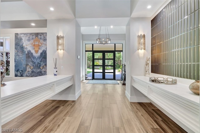 interior space featuring a notable chandelier, french doors, vanity, and wood-type flooring