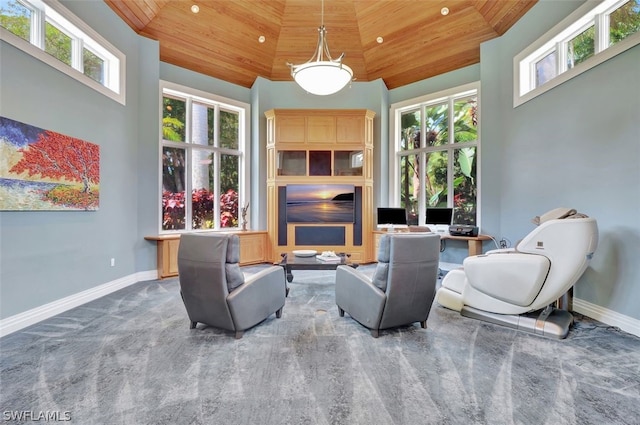 sitting room featuring wood ceiling, carpet floors, and a wealth of natural light