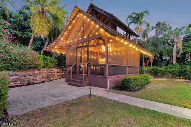 property exterior at dusk with a lawn