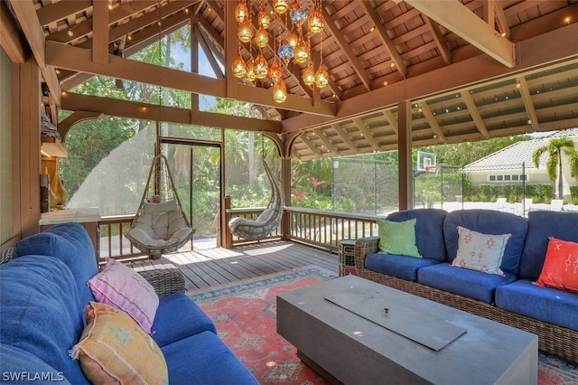 sunroom with an inviting chandelier, lofted ceiling with beams, and wood ceiling