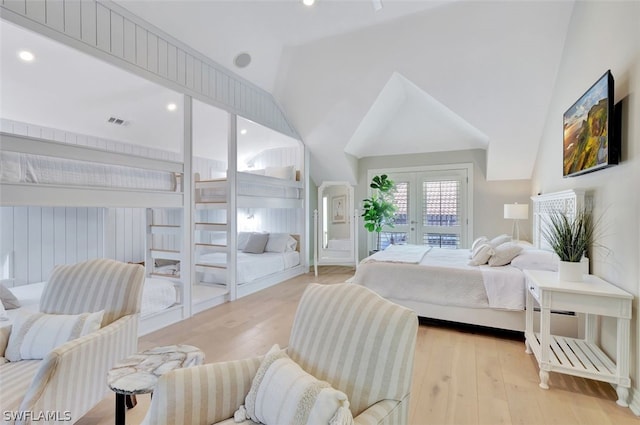 bedroom with french doors, lofted ceiling, and light wood-type flooring