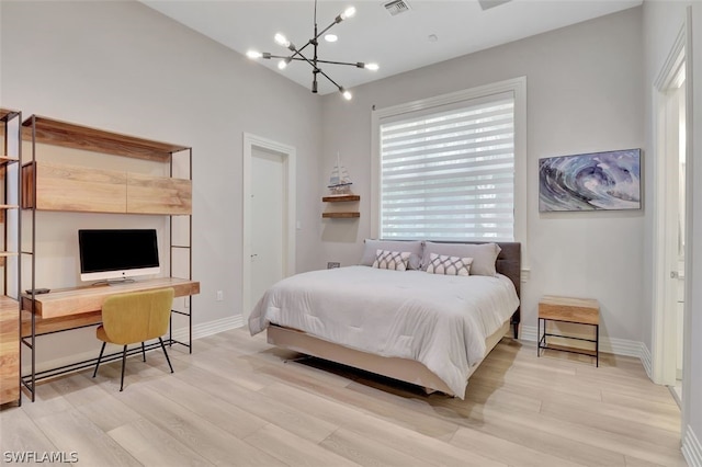 bedroom featuring a chandelier and light hardwood / wood-style floors