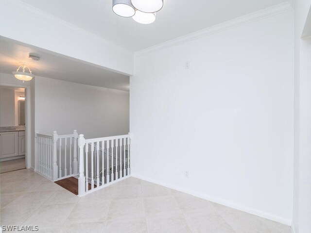 tiled spare room with ornamental molding