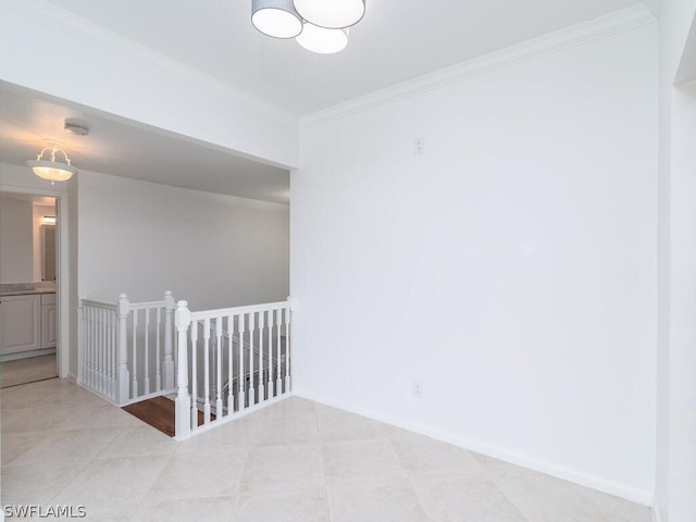 empty room with crown molding and light tile patterned floors