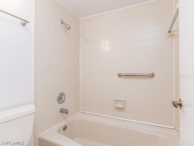 bathroom featuring tiled shower / bath combo and toilet