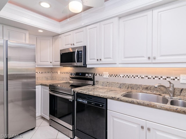 kitchen with appliances with stainless steel finishes, backsplash, white cabinetry, ceiling fan, and ornamental molding