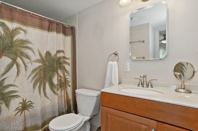 bathroom featuring curtained shower, vanity, and toilet