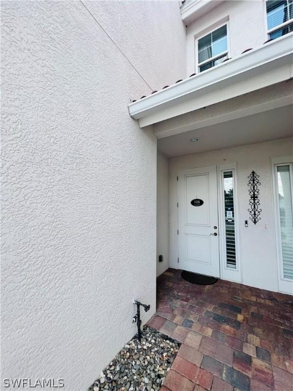 entrance to property featuring stucco siding