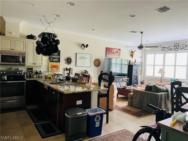 kitchen featuring cream cabinetry, crown molding, visible vents, appliances with stainless steel finishes, and light tile patterned flooring