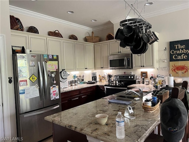 kitchen with light stone countertops, tasteful backsplash, appliances with stainless steel finishes, and crown molding