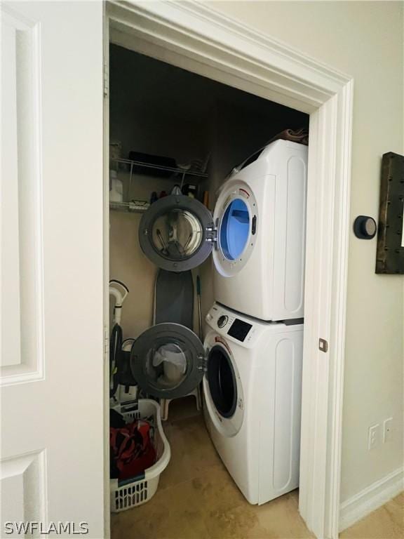 clothes washing area with laundry area and stacked washing maching and dryer